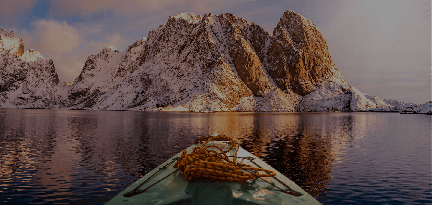 kayak on a lake near snow capped mountains in norway, scandinavia